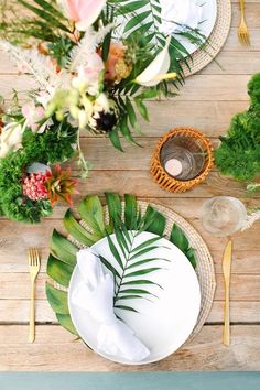 the table is set with plates, silverware and flowers