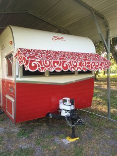 a red and white trailer parked under a tent