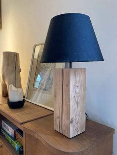 a wooden table with a lamp on top of it next to a book case and other items