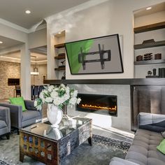 a living room filled with furniture and a fire place in front of a wall mounted tv