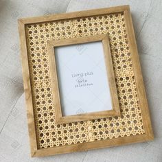 a wooden frame sitting on top of a white table next to a cup and saucer