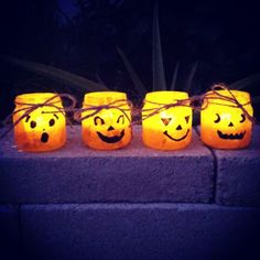 four pumpkin jars with faces tied to them