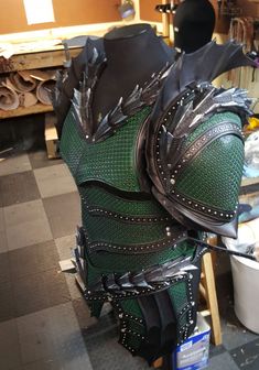 a large green and black armor on display in a room