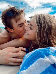 a man and woman laying on top of a boat