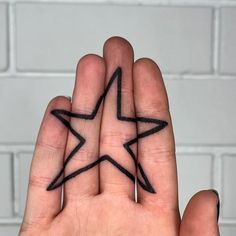 a person's hand with a star tattoo on it