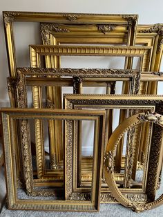 a group of gold frames sitting on top of a carpet