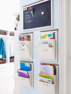 a wall mounted magnetic board with file folders and clipboards attached to the back of it