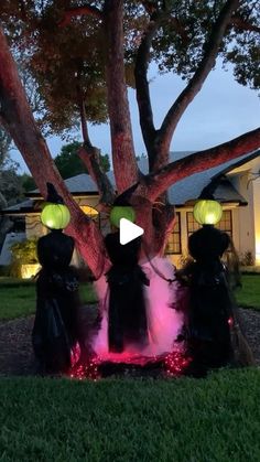 two people dressed in black standing under a tree with glowing lights on their heads and hands