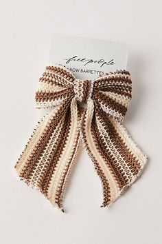 the brown and white striped bow is attached to a card with an inscription on it