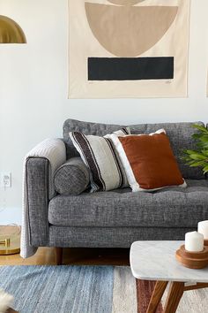 a living room filled with furniture and a painting on the wall