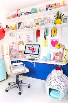 a desk with a computer on top of it and lots of shelves above the desk