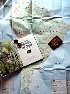 a map, passport, and other items are laying on top of each other in this photo