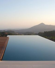 an empty swimming pool with mountains in the background