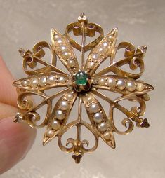 A 15K emerald seed pearls starburst Gothic flower pin brooch from the 1880s.  This fine 1-1/8" Victorian yellow gold pin is in the Aesthetic style and it is an unusually ornate flower star burst with somewhat Gothic heart-shaped gold flourishes.  The central stone is a natural (tested) emerald and it is surrounded by graduated seed pearls.  This pin has the original c-clasp and it is unsigned;  we've tested it and it tests as at least 15 carat gold, possibly a bit more.  It weighs 4.3 grams and it is in excellent condition with no breaks, damage or known repairs.   Jewelry will have signs of use as expected. Expedited parcel to the US starts at $24.00 and expedited parcel within Canada starts at $19.00 (tracking and loss insurance is included). At this time, we are required to opt for a si 1880s Aesthetic, Jada Billalu, K Aesthetic, Jewel Brooch, Gothic Flowers, Star Burst, Jewellery Sketches, Gold Brooch, Gold Pin