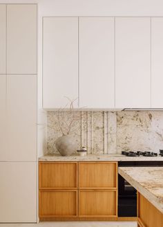 a kitchen with marble counter tops and wooden cabinets