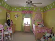 a child's bedroom decorated in pink, green and white with polka dots on the walls