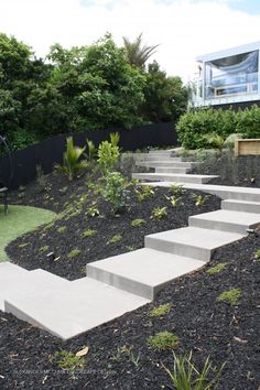 a set of stairs leading up to the top of a hill in front of a house