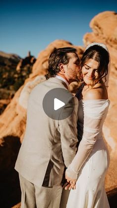 a bride and groom kissing in the desert