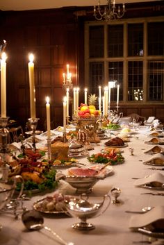 a long table is set with silverware and candles for a formal dinner or party