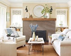 a living room filled with furniture and a fire place in front of a brick fireplace