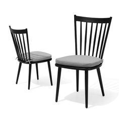 two black chairs sitting next to each other on a white background, one with a gray cushion