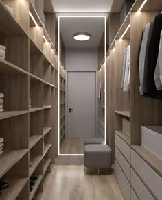 a walk - in closet with wooden shelves and white drawers is lit by recessed lighting