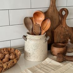 some wooden spoons and other kitchen utensils in a white container on a counter