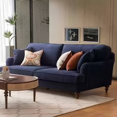 a living room with a blue couch and coffee table in front of a large window