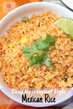 mexican rice in a white bowl with cilantro and lime garnish on top