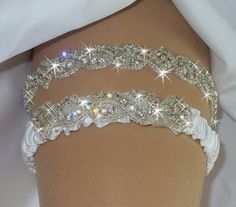 three white garters with crystal stones on them