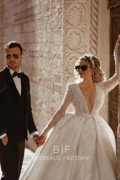 a man in a tuxedo and a woman in a wedding dress holding hands