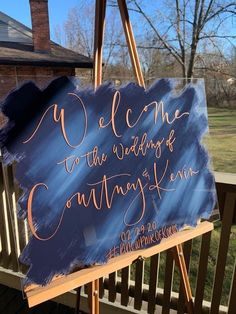 a welcome sign on an easel in front of a house