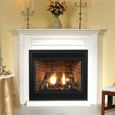 a fire place in a living room filled with furniture and flowers on top of the fireplace