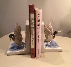 two bookends made to look like ducks are sitting on a table next to each other