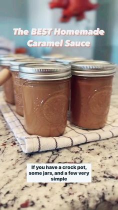 three jars of homemade caramel sauce sitting on top of a kitchen counter next to a towel