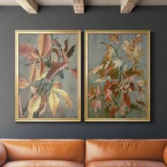 two paintings hanging on the wall above a couch in a living room with leather furniture