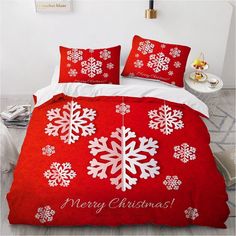 a red bed with white snowflakes on it and merry christmas written on the comforter