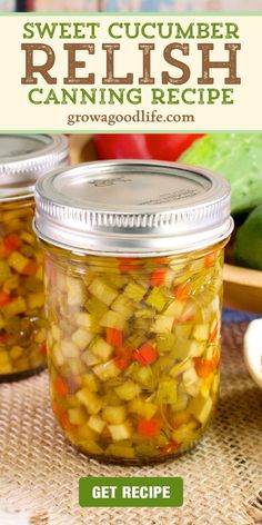 two jars filled with pickles sitting on top of a table next to some vegetables