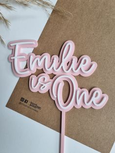 a pink cake topper that says,'emple and one'on it