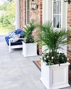 two white planters sitting on the front porch