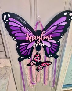 purple and black butterfly door hanger with name on it's side, hanging from the front door