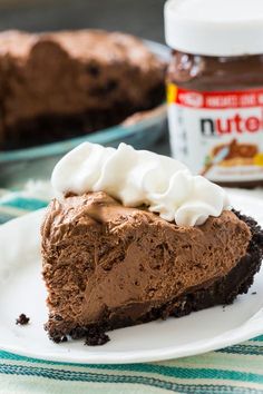 a slice of chocolate pie on a plate with whipped cream and nutella in the background