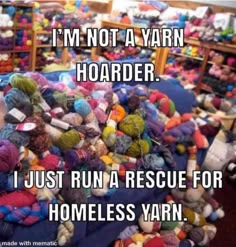 a pile of yarn sitting on top of a floor next to a shelf filled with balls of yarn