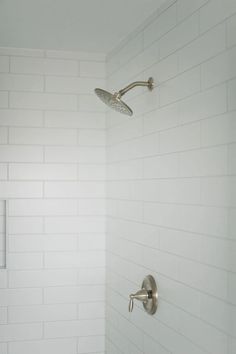 the shower head and hand shower faucet are all white in this modern bathroom