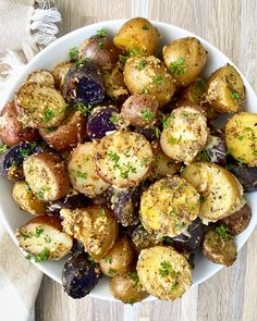 a white bowl filled with cooked potatoes on top of a wooden table