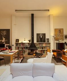 a living room filled with furniture and bookshelves next to a fire place in the fireplace