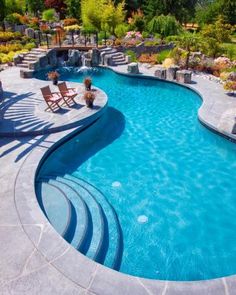 an outdoor swimming pool surrounded by landscaping