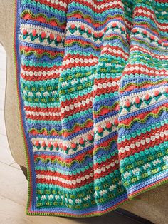 a multicolored crocheted afghan on a couch