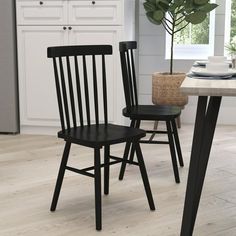 two black chairs sitting next to each other in a kitchen