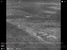 black and white photo of an aerial view of a town with trees in the foreground